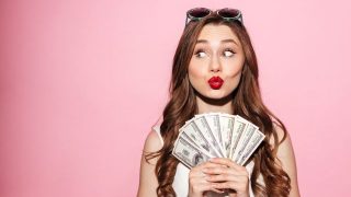 お札を広げて持つ女性
