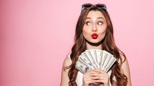 お札を広げて持つ女性