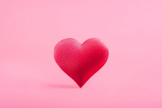 ピンクの背景の前にあるピンクのハート